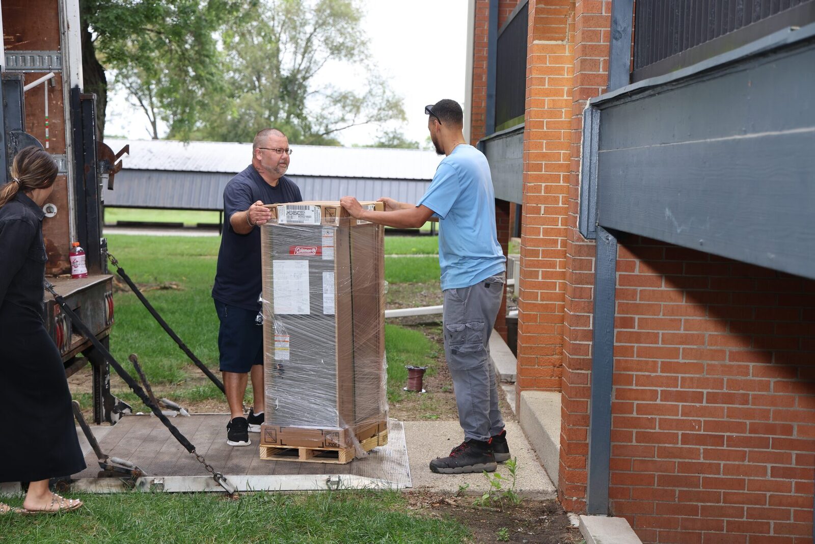 All Weather Comfort Solutions crew delivering new equipment at a multi-family building