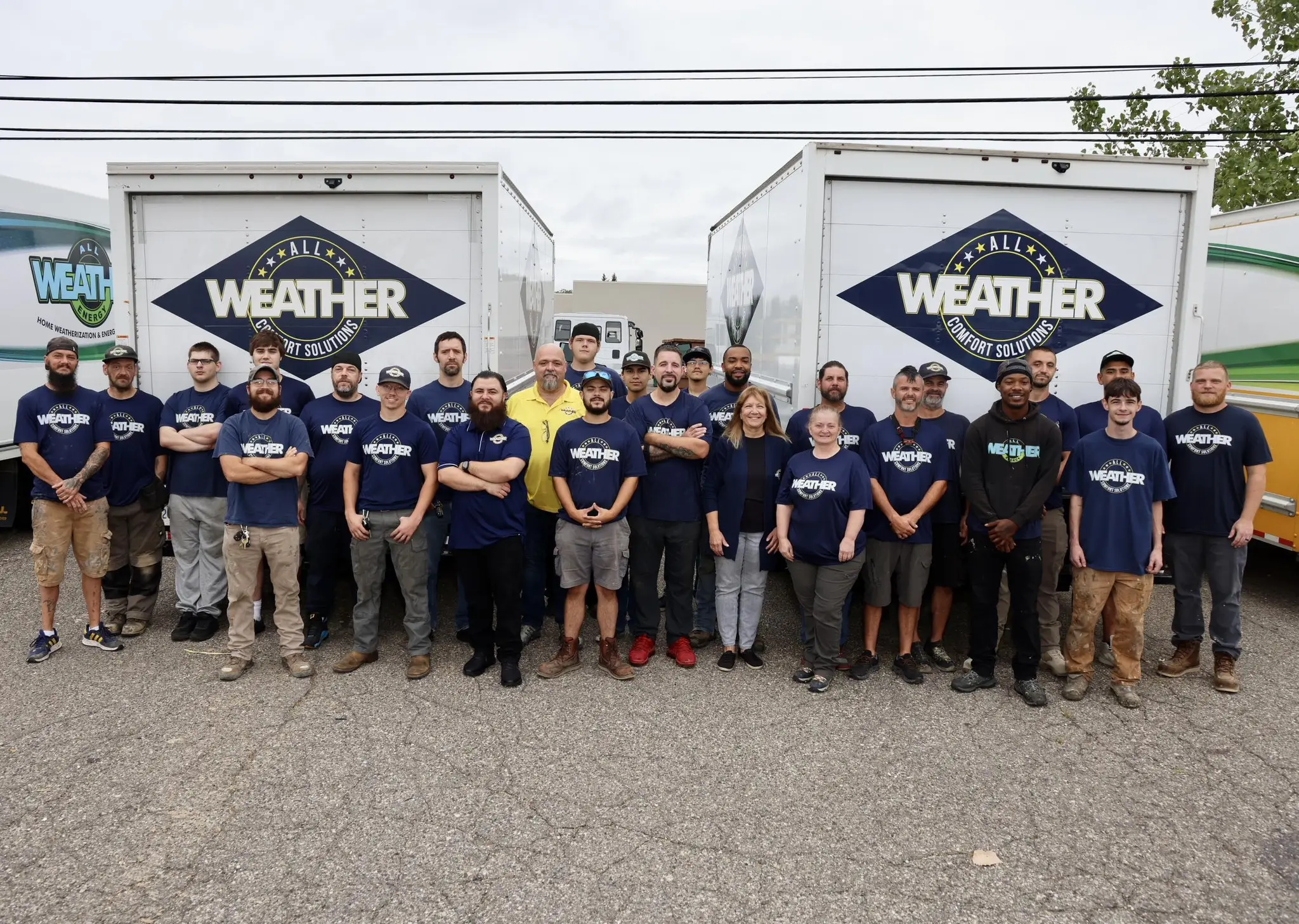 The full All Weather Comfort Solutions crew lined up in front of two branded box trucks