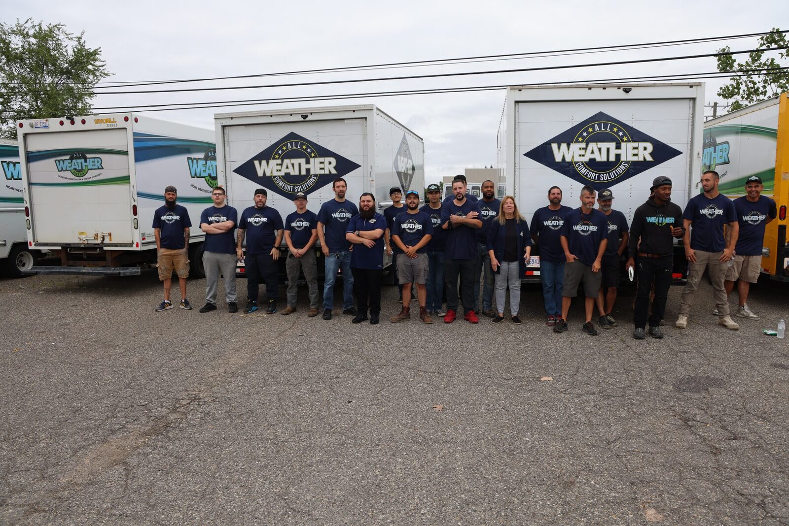 The All Weather Comfort Solutions team in front of their branded trucks