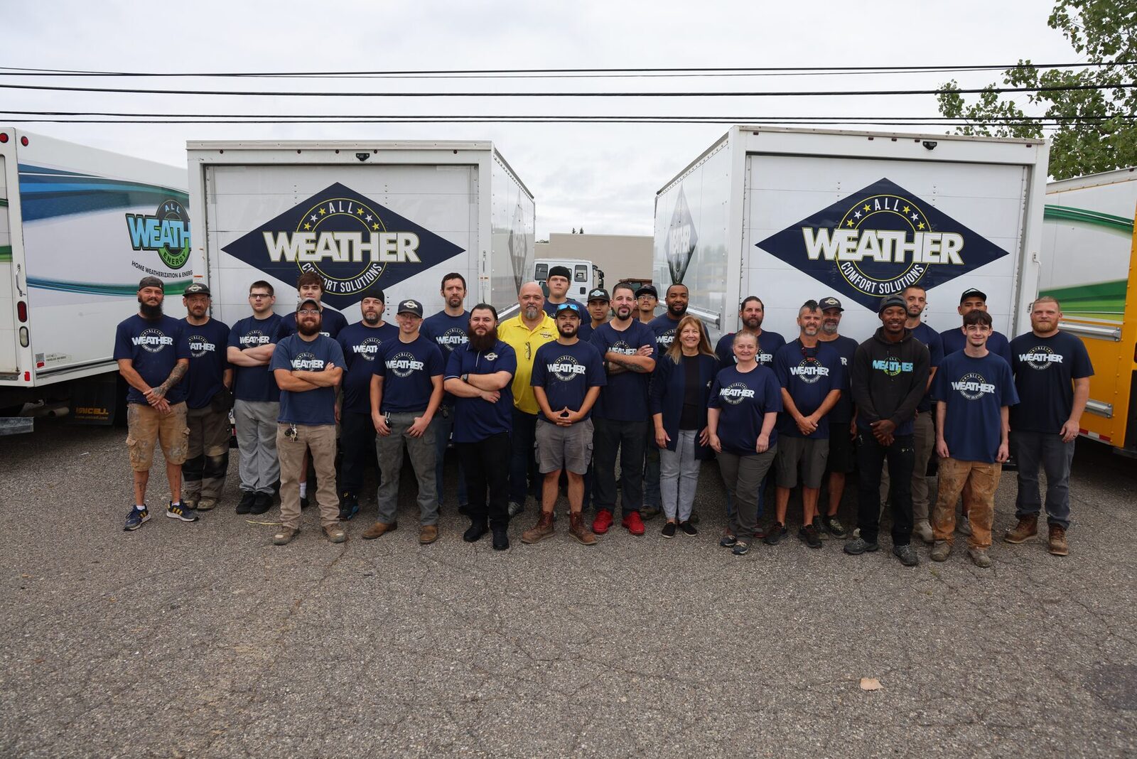 The All Weather Comfort Solutions crew lined up in front of their logo trucks