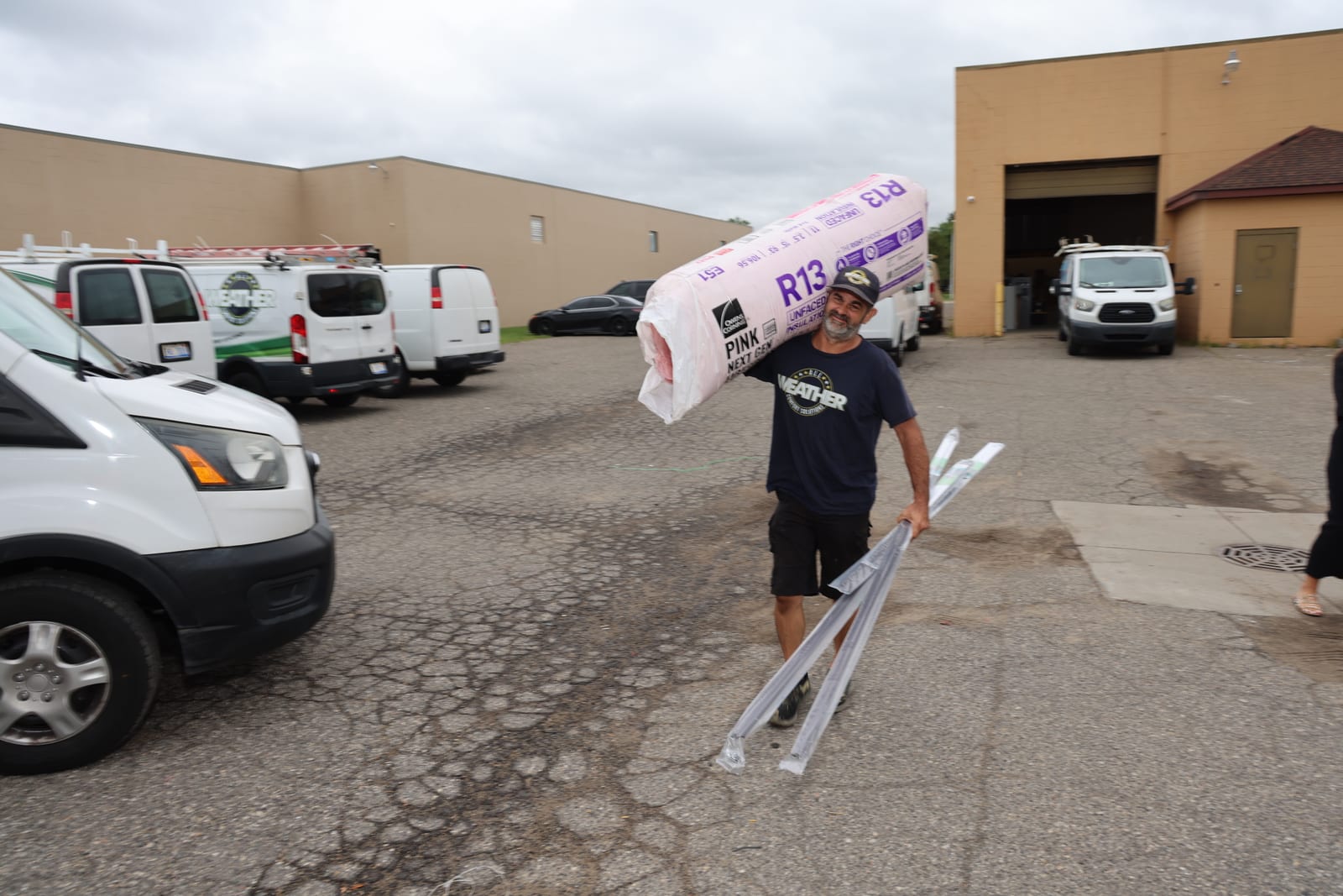 All Weather Comfort Solutions technician carrying insulation to a job