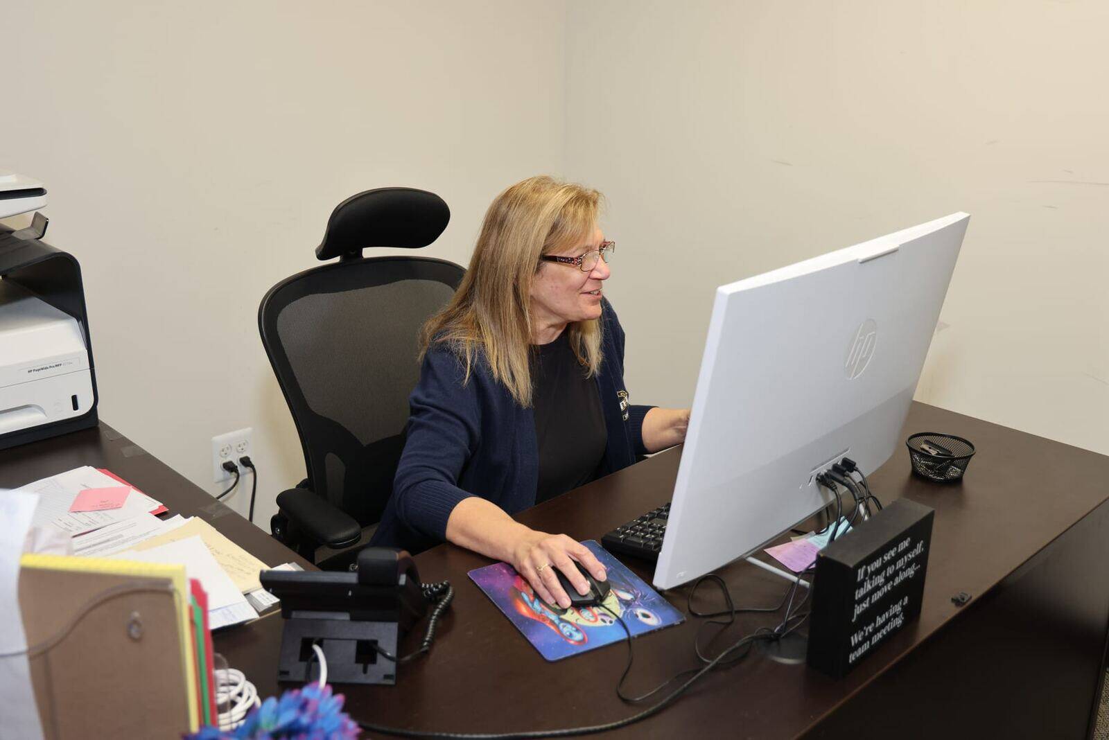 An All Weather Comfort Solutions team member handling paperwork at the office