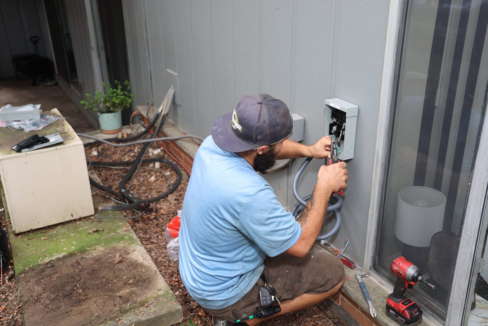 An All Weather Comfort Solutions technician servicing HVAC electrical connections