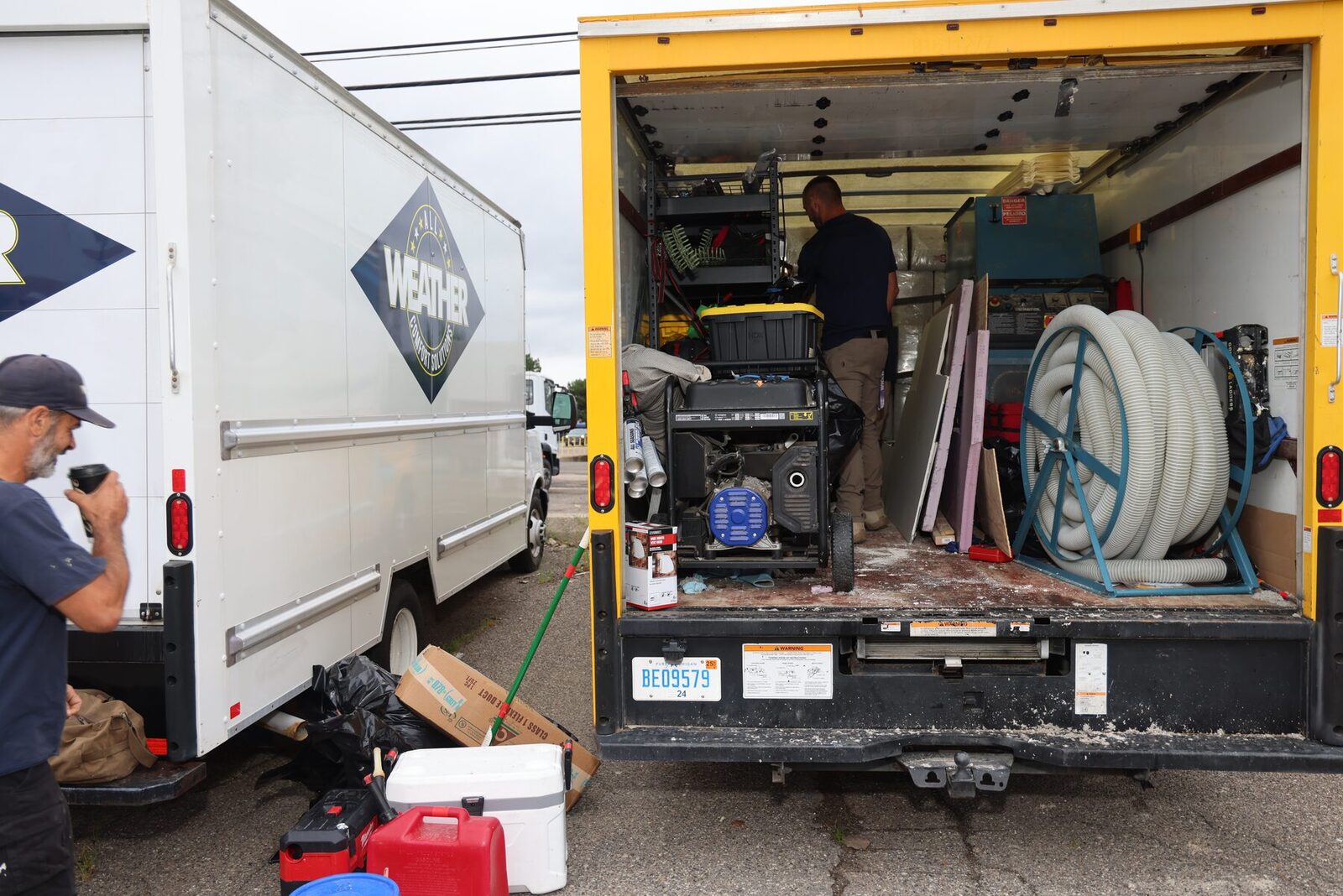 An All Weather Comfort Solutions technician loading a branded box truck